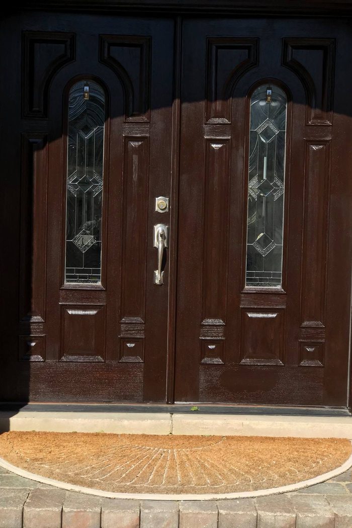 Double entry doors refinished in a deep mahogany tone