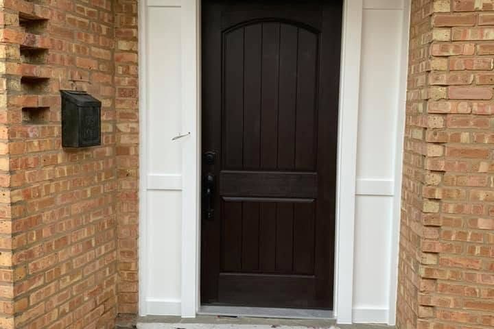 Front entry with dark-stained door and freshly painted white trim