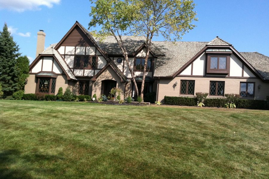 Tudor-style home exterior with repainted trim and stucco
